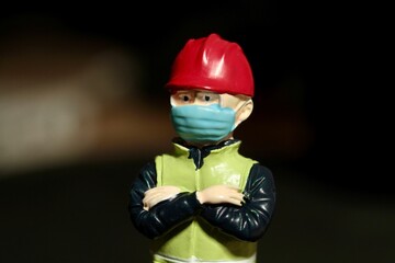miniature figurine of a worker with an helmet and a protective mask