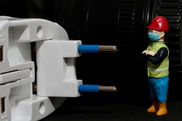 miniature figurine of an electrician with an electric plug