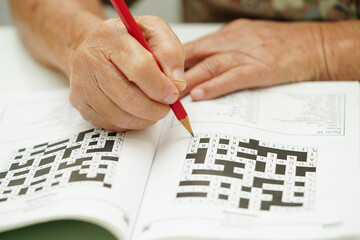 elderly woman playing sudoku puzzle game for treatment dementia prevention and Alzheimer disease.