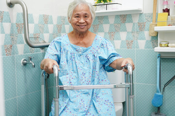 Asian elderly old woman patient use toilet support rail in bathroom, handrail safety grab bar,...