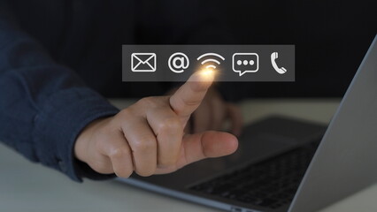 Contact us or Customer support hotline people connect. Businessman using a laptop and touching on virtual screen contact icons ( email, address, live chat, internet wifi ).