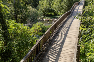 Foot bridge over river in mediterranean forest, located in northern Spain, in the province of...