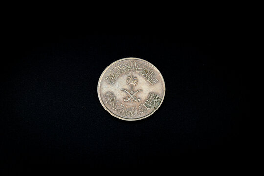 Crossed swords and palm tree at center flanked by dates, legend above and below on old Suudi Arabia coin 50 halalah  from1977, tail side
