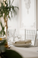 Table setting, glasses for drinks, plates, flowers