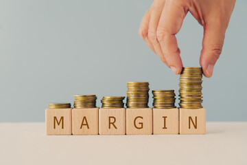 margin text on wooden cube blocks with hand arranged stack of coins including copy space