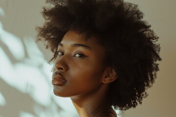 A minimalist portrait of a woman with a bare face, natural hair, and simple clothing, against a neutral backdrop
