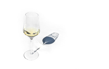 Glasse with white wine, flat lay. Pastel light table in sunlight with long shadow.