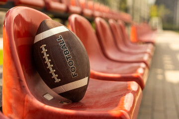 American football ball on the tribune of the stadium