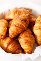 Fresh baked croissants on white table.