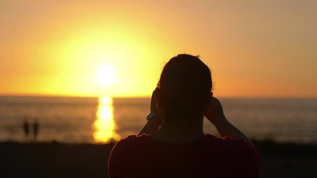Woman takes picture of sunset in California in 4k slow motion 60fps