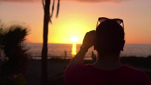 Woman takes picture of sunset in California in 4k slow motion 60fps