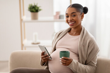 Closeup of happy african american expecting lady with cell phone