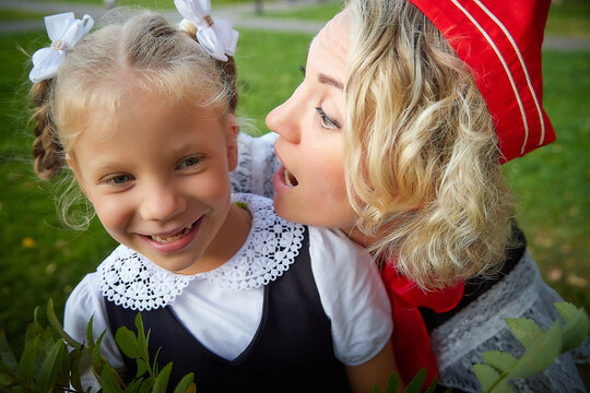 Young and adult schoolgirl on September 1. Generations of schoolchildren of USSR and modern Russia. Female pioneer in red tie and October girl in modern uniform. Mother and daughter having fun