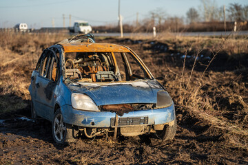 burned car wreck near to highway - 717639495