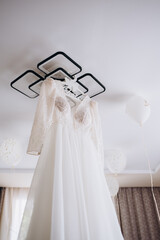 Wedding dress hanging on a wooden chandelier. High quality photo