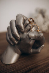 wedding rings on a stand ceramic hands