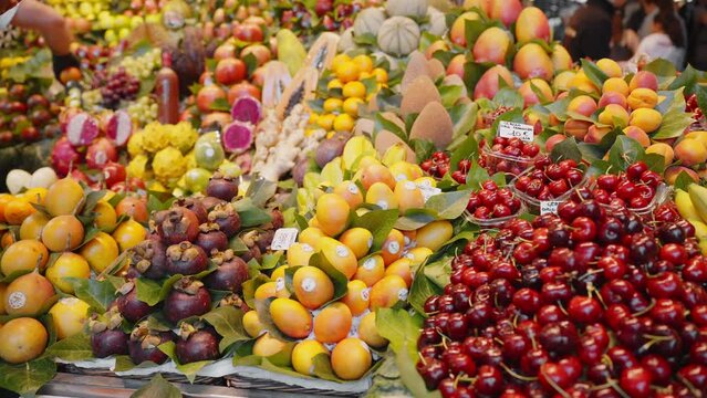 Exotic fruits and vegetables Central Market Barcelona, Spain showcase cherries, mango, papaya, apricots of fresh beautifully arranged. Healthy nutrition, health and vitamins