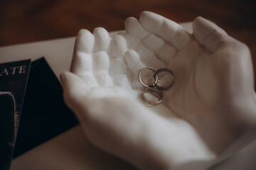 wedding rings on a stand ceramic hands