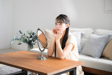鏡をみて肌のチェックするアジア系（日本人）女性　スキンケア