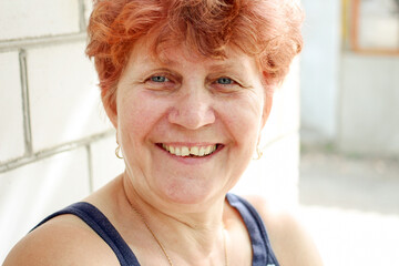 Adult woman with short red hair smiling at camera