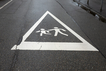 Caution: Children Playing - Urban Street Safety Sign on Wet Pavement