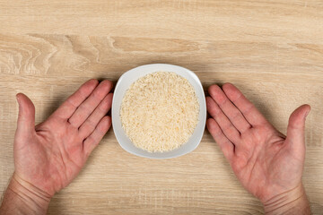 Hands Placing White Rice Bowl - Hunger, Food and Agricultural Greenhouse Gas Emissions Concept, Top...