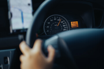 Driving a car on high speed. Focused on speedometer.