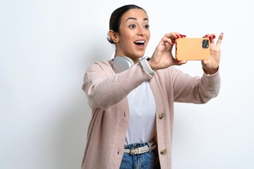 Young beautiful woman taking a selfie to post it on social media or having a video call with...