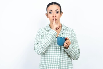 MODEL silence gesture keeps index finger to lips makes hush sign. Asks not to share secret