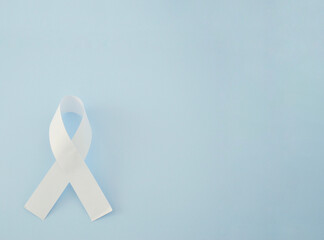 White ribbon as a symbol of peace on a blue background. World Day of Peace. International Day Of Human Fraternity. International Day of Living Together in Peace. International Human Solidarity Day