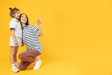 Mother and daughter are talking, on a yellow background.