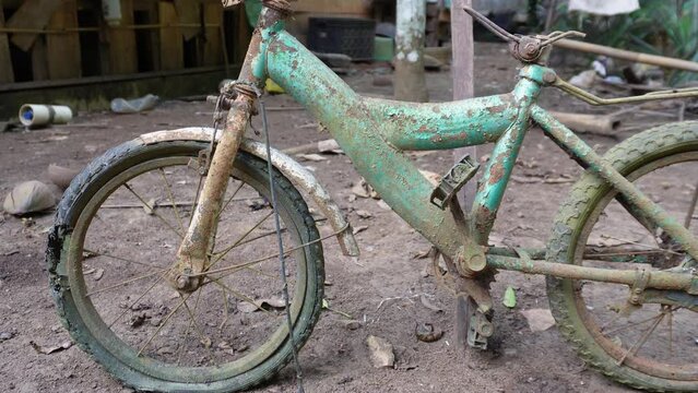 Broken green bike with leaking wheel and it's rusty in 4K video. Wheeless bike. Crash bicycle