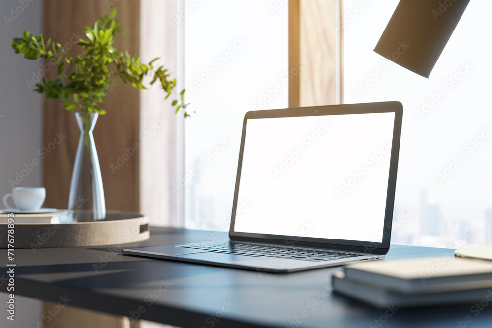 Poster Contemporary designer desktop with white mock up laptop, various objects and window with city view in the background. 3D Rendering.