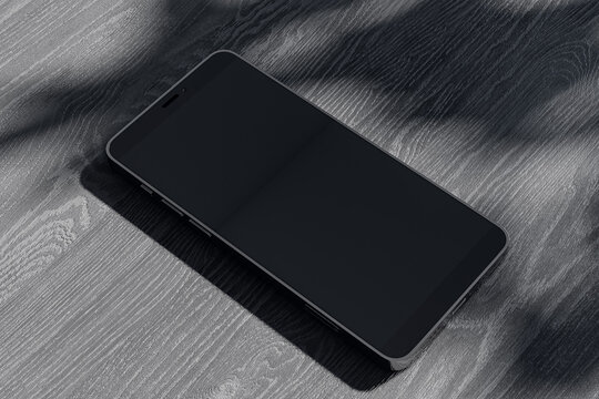 Close Up Of Empty Mobile Phone On Dark Wooden Surface With Leaf Shadows. Presentation Concept. Mock Up, 3D Rendering.