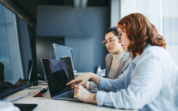 Professional business team collaborating on software development in modern office setting