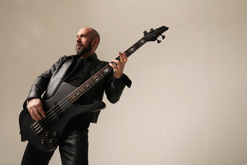 Obraz premium Rock musician. A man with black electric guitar poses at the studio.Mock-up.