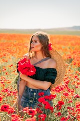 Woman poppies field. portrait happy woman with long hair in a poppy field and enjoying the beauty of nature in a warm summer day.