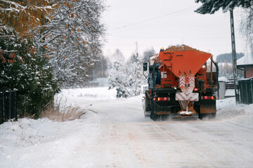 Tractor with mounted salt and sand spreader, road maintenance - winter gritter vehicle. Municipal...