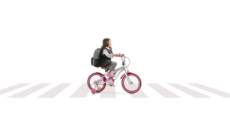 Obraz premium Schoolgirl riding a bicycle at a pedestrian crossing