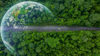Aerial top view of green electric vehicle car driving over straight forest road, EV car electric...