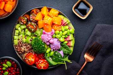 Vegan buddha bowl with pumpkin, quinoa, tomatoes, spinach, celery, radish, edamame, tofu, broccoli...