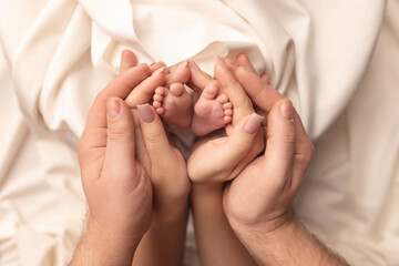 Children's feet in the arms of their parents. On a white background.