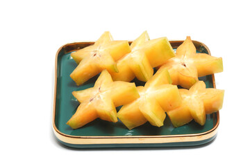 Sliced fresh organic star fruit delicious in a green plate isolated on white background clipping path