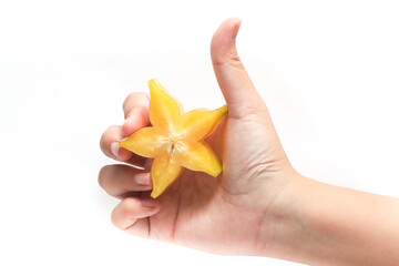 Hand holding sliced and whole fresh organic star fruit delicious with thumb finger isolated on white background clipping path