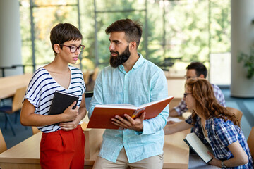 Happy group of students studying and working together in a college library