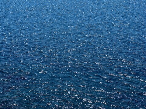 Blue water glittering calm surface. 