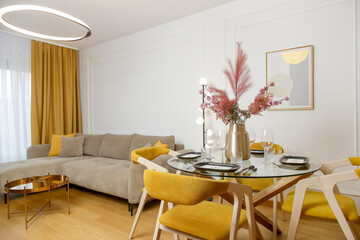 Modern cozy apartment with a touch of yellow, living room with sofa and dining table, 