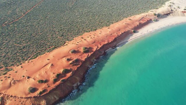 Video of Cape Peron from the sky. Aerial video of red and rocky land next to the beach and ocean in Francois Peron National Park, Shark Bay, Western Australia. Drone video.