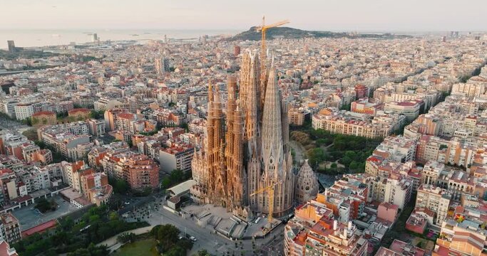 Sagrada Familia Barcelona, Spain Eixample residential area. Architectural heritage of country in summer on sunny day blue sky aerial view slide drone turn. Go Everywhere Travel. UNESCO. Tourism