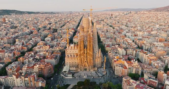 Sagrada Familia Barcelona, Spain Eixample residential area. Architectural heritage of country in summer on sunny day blue sky aerial view slide drone turn. Go Everywhere Travel. UNESCO. Tourism